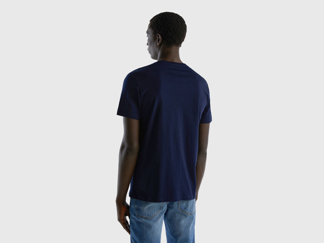 Back view of a man wearing a dark blue t-shirt and jeans. Simple, classic fit.