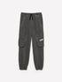 Front view of dark grey joggers with functional cargo-style pockets on the sides and an adjustable drawstring waist, a versatile choice for loungewear or active wear in Kuwait.
