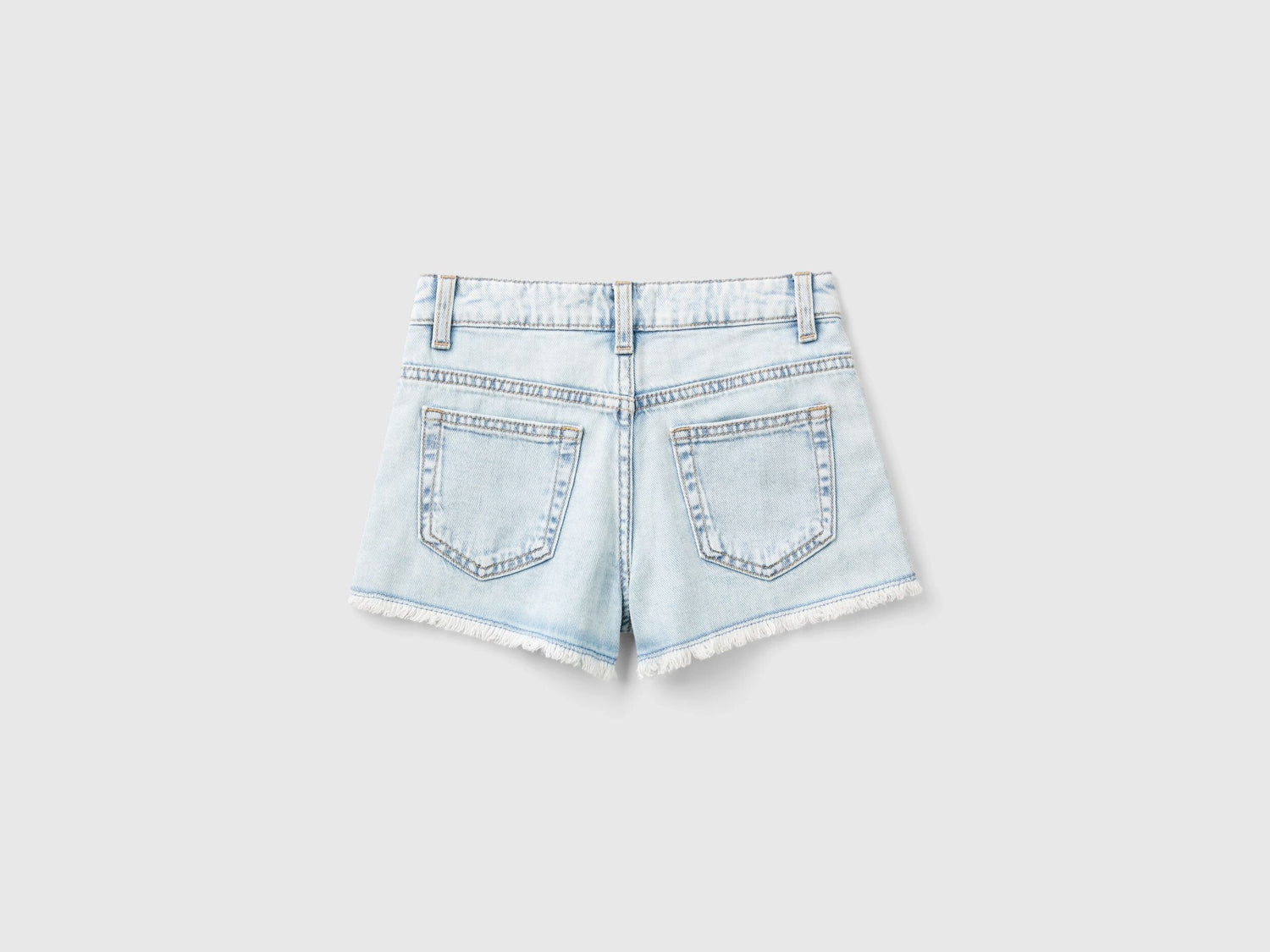Back view of light wash denim shorts for girls with butterfly embroidery.