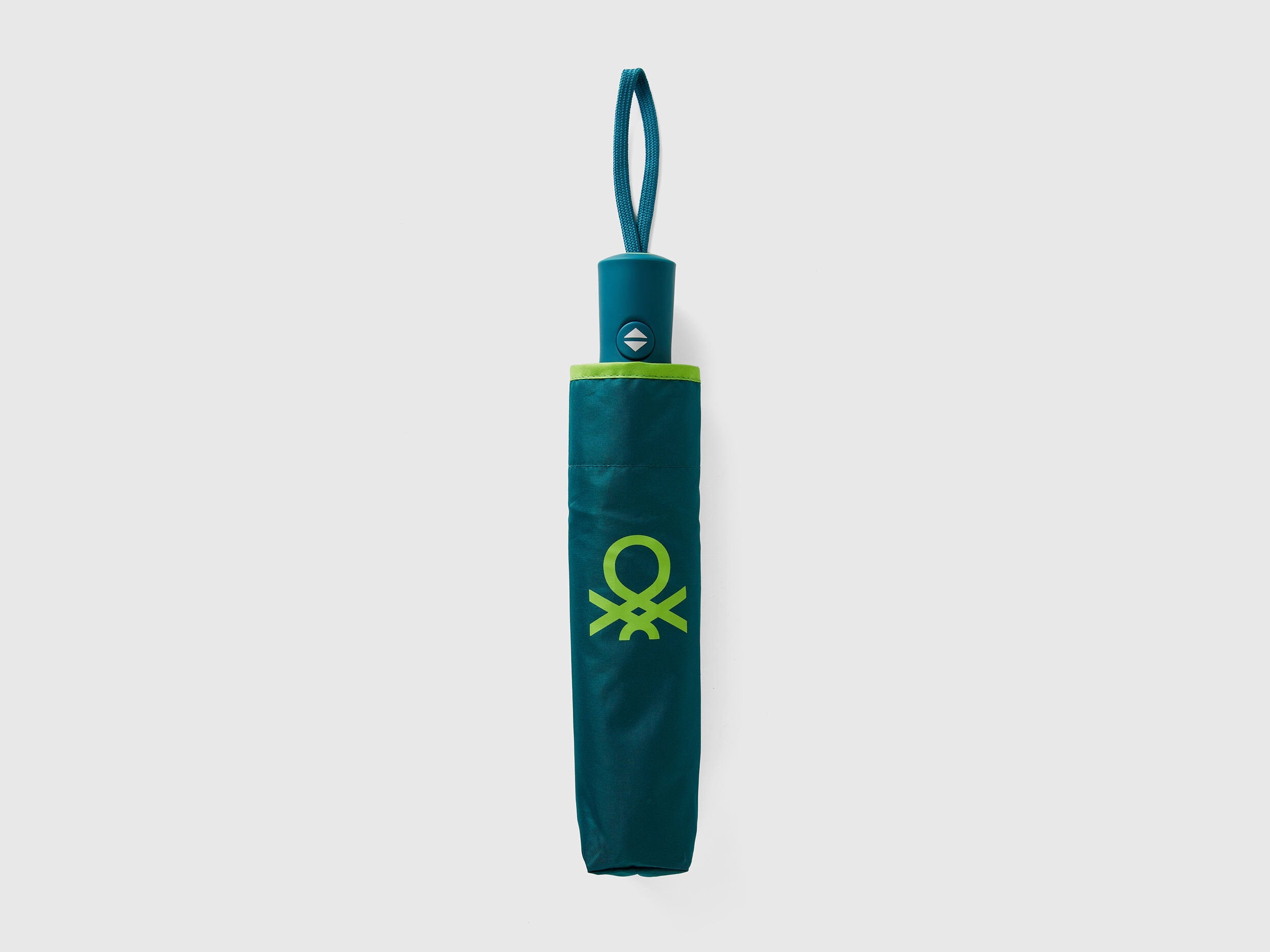 Folded green Benetton umbrella, compact for portability.