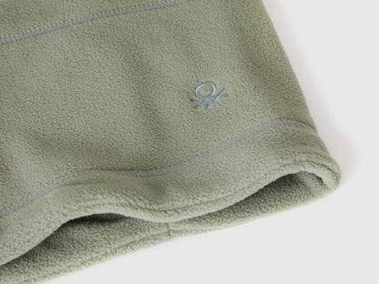 Close-up of green fleece neck warmer with Benetton logo.