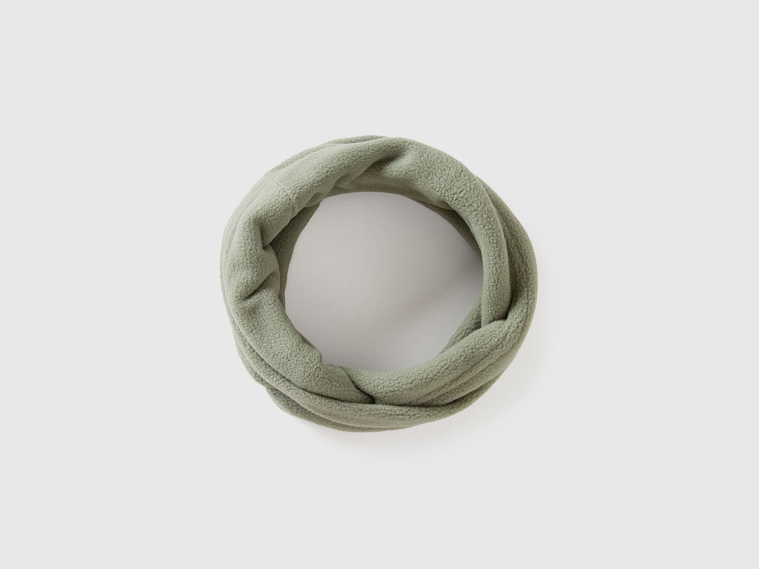 Green fleece neck warmer, rolled for comfort and warmth.
