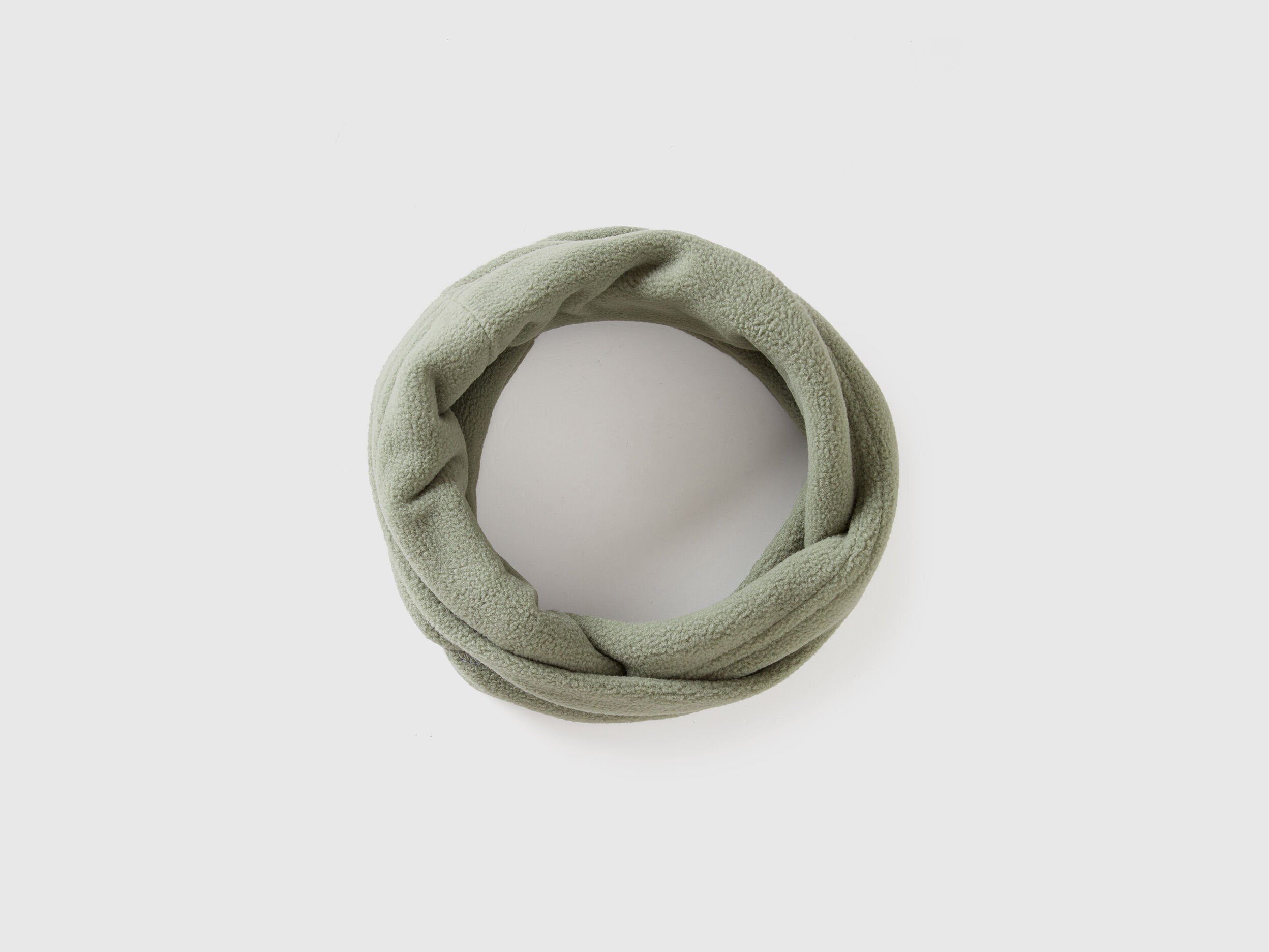 Green fleece neck warmer, rolled for comfort and warmth.