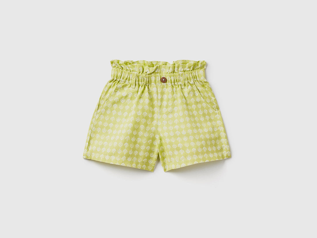 A flat lay, front view of a pair of green linen-blend shorts with a paperbag waist and a matching tie belt, a fashionable choice for the climate in Kuwait.
