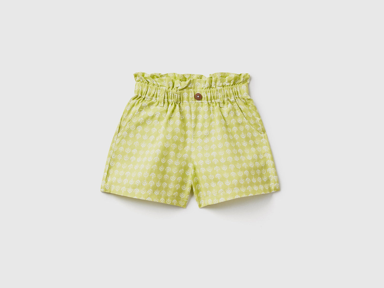 A flat lay, front view of a pair of green linen-blend shorts with a paperbag waist and a matching tie belt, a fashionable choice for the climate in Kuwait.