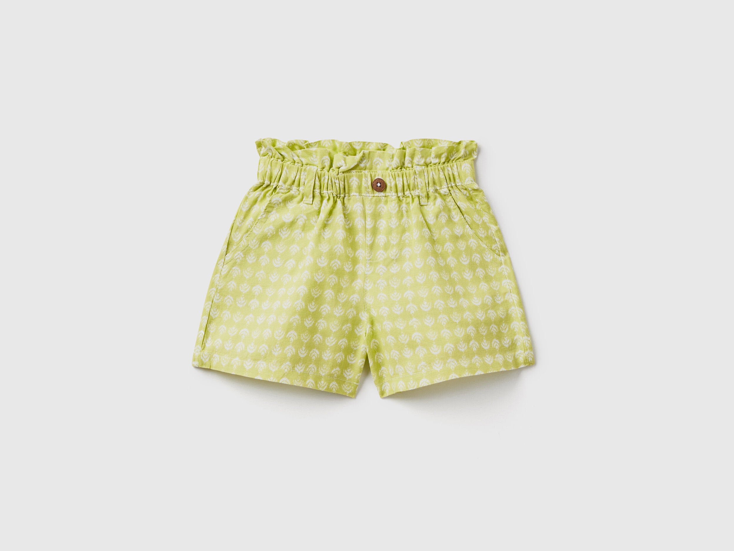 A flat lay, front view of a pair of green linen-blend shorts with a paperbag waist and a matching tie belt, a fashionable choice for the climate in Kuwait.
