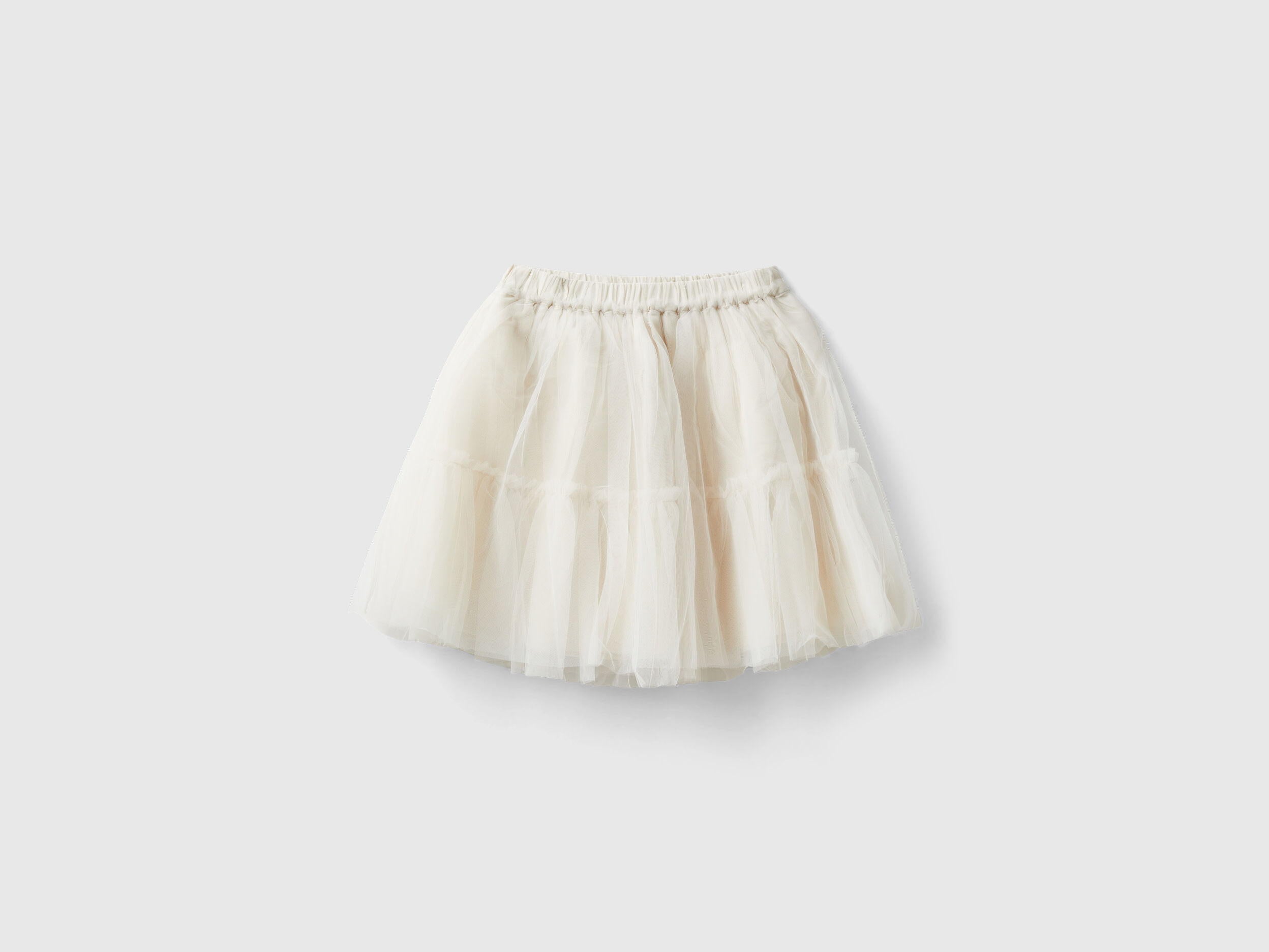 Front view of a whimsical cream-colored tulle skirt for kids, featuring multiple ruffled layers.