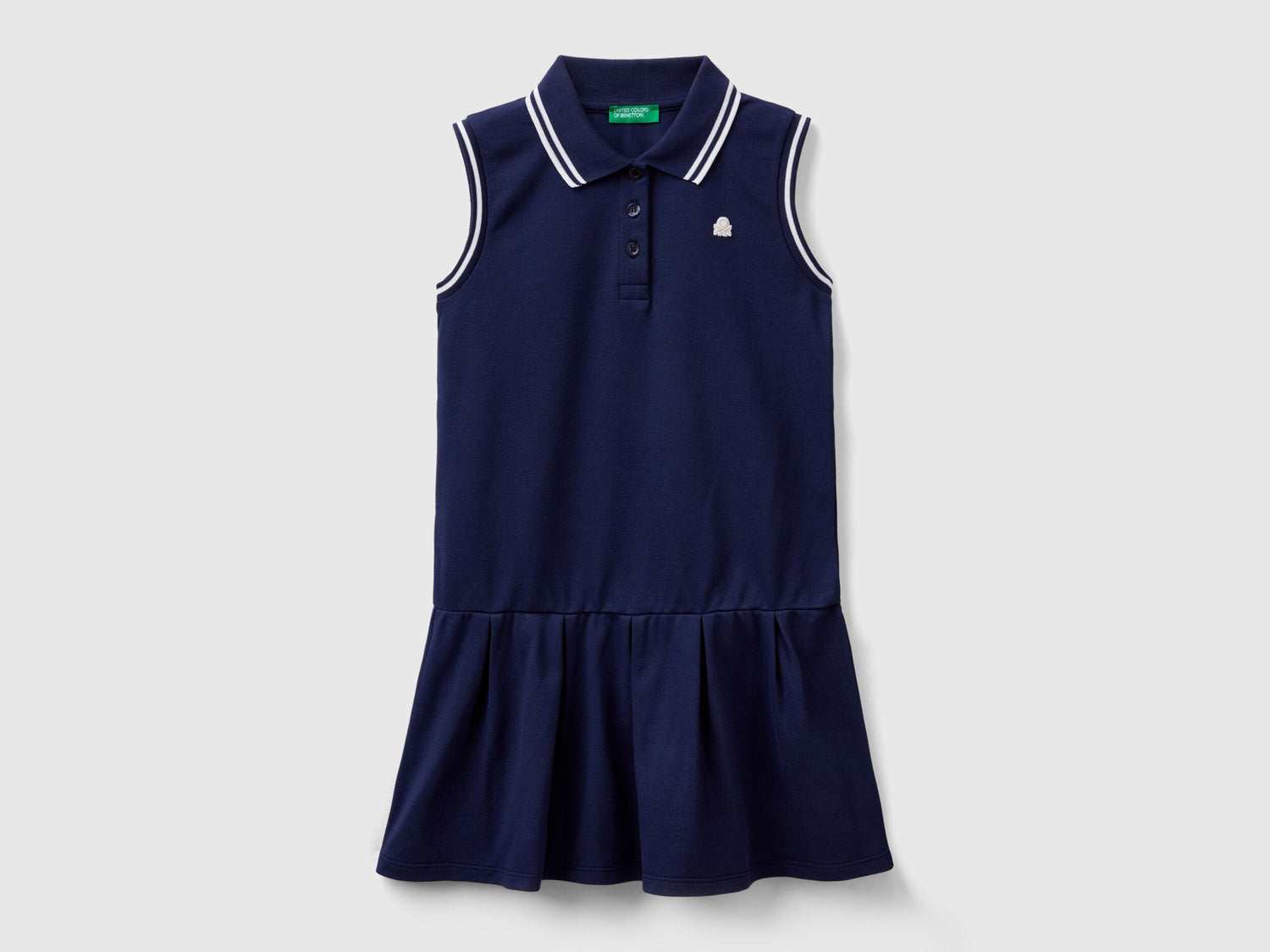 Front view of a navy blue polo dress for kids, featuring a white striped collar and ruffled skirt.