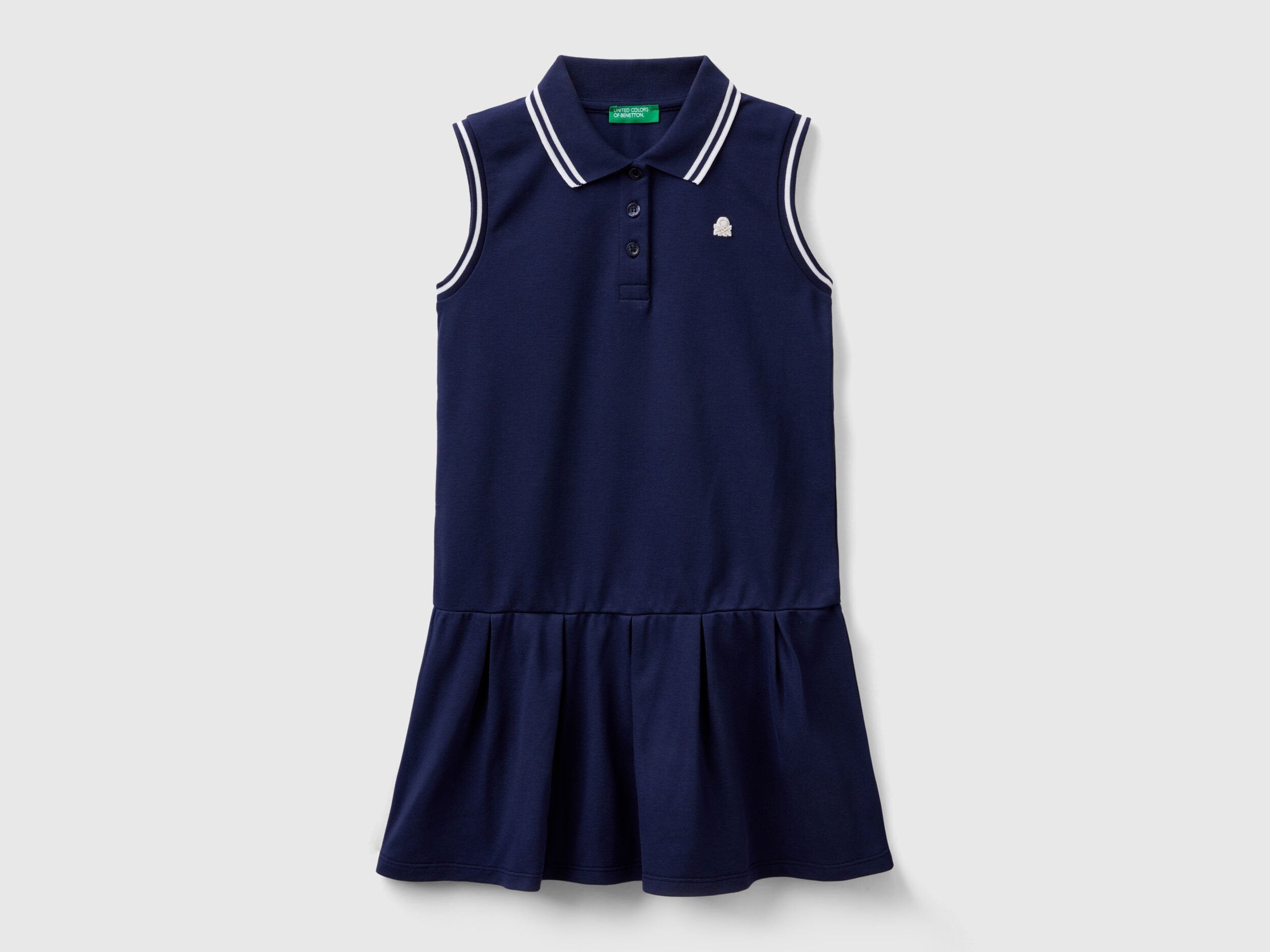 Front view of a navy blue polo dress for kids, featuring a white striped collar and ruffled skirt.