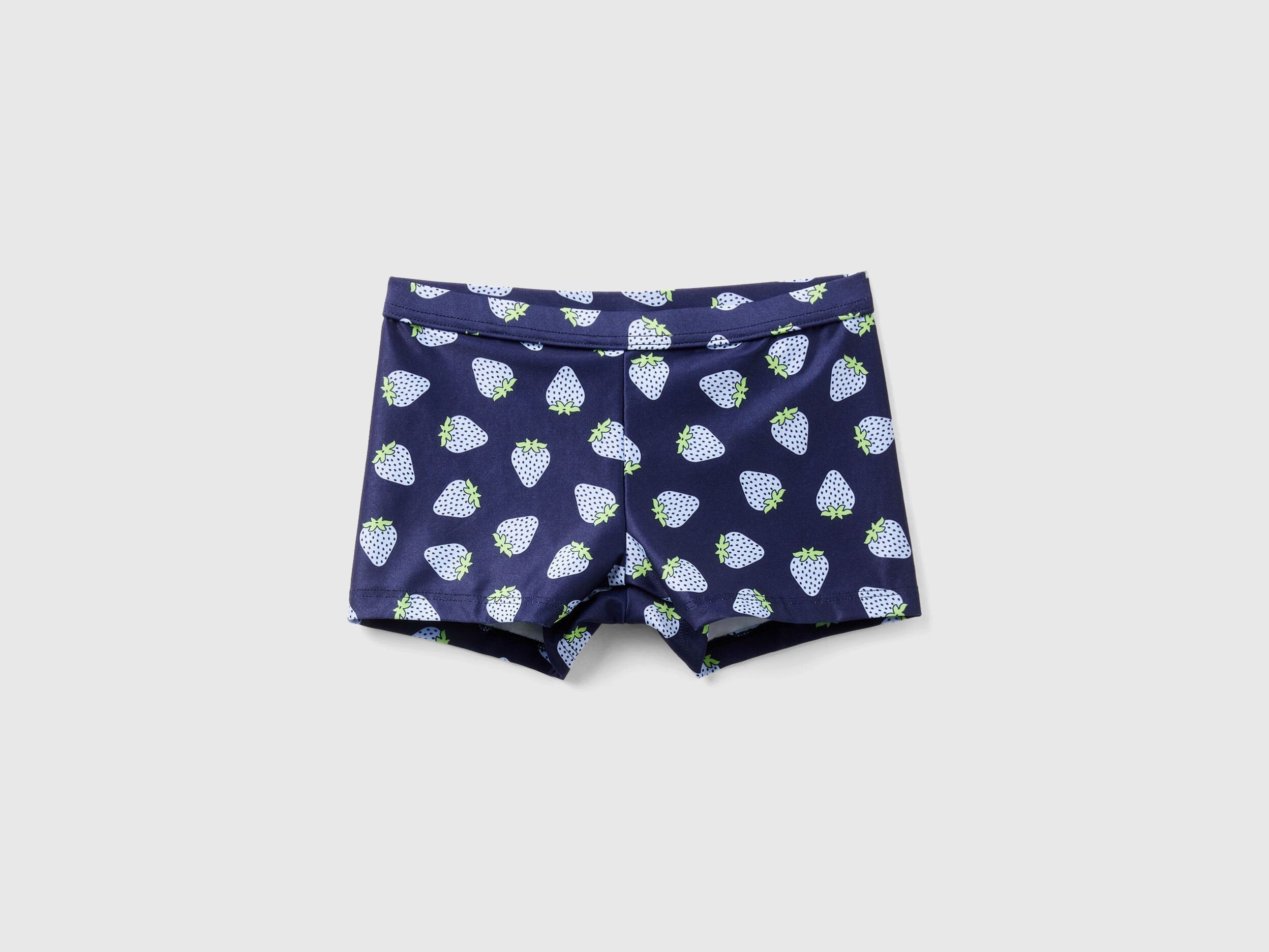 Navy blue swim trunks for kids with an all-over white and light blue strawberry pattern, ideal for beach or pool wear.
