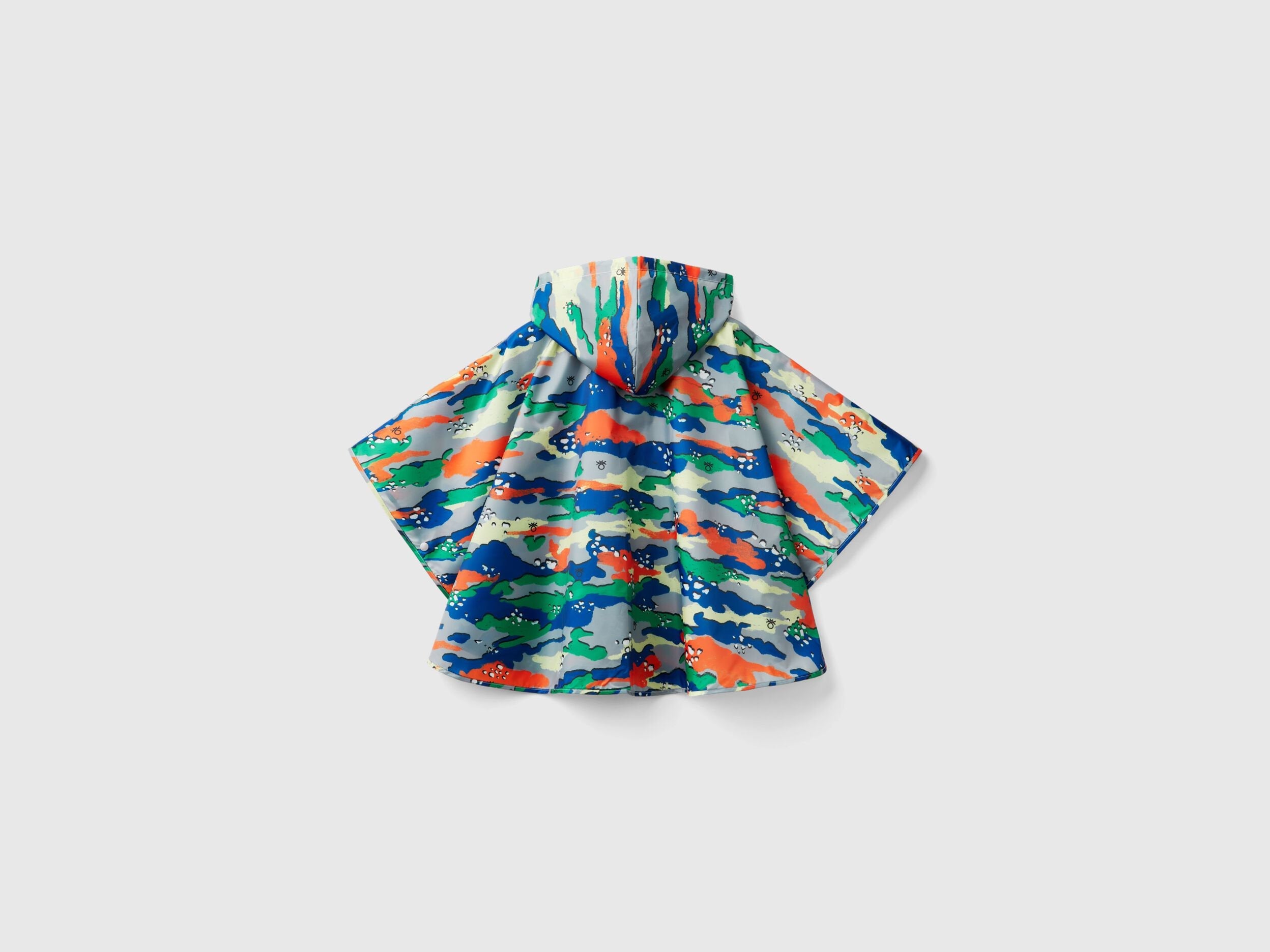 Flat lay of a vibrant, multi-colored patterned rain poncho for kids.