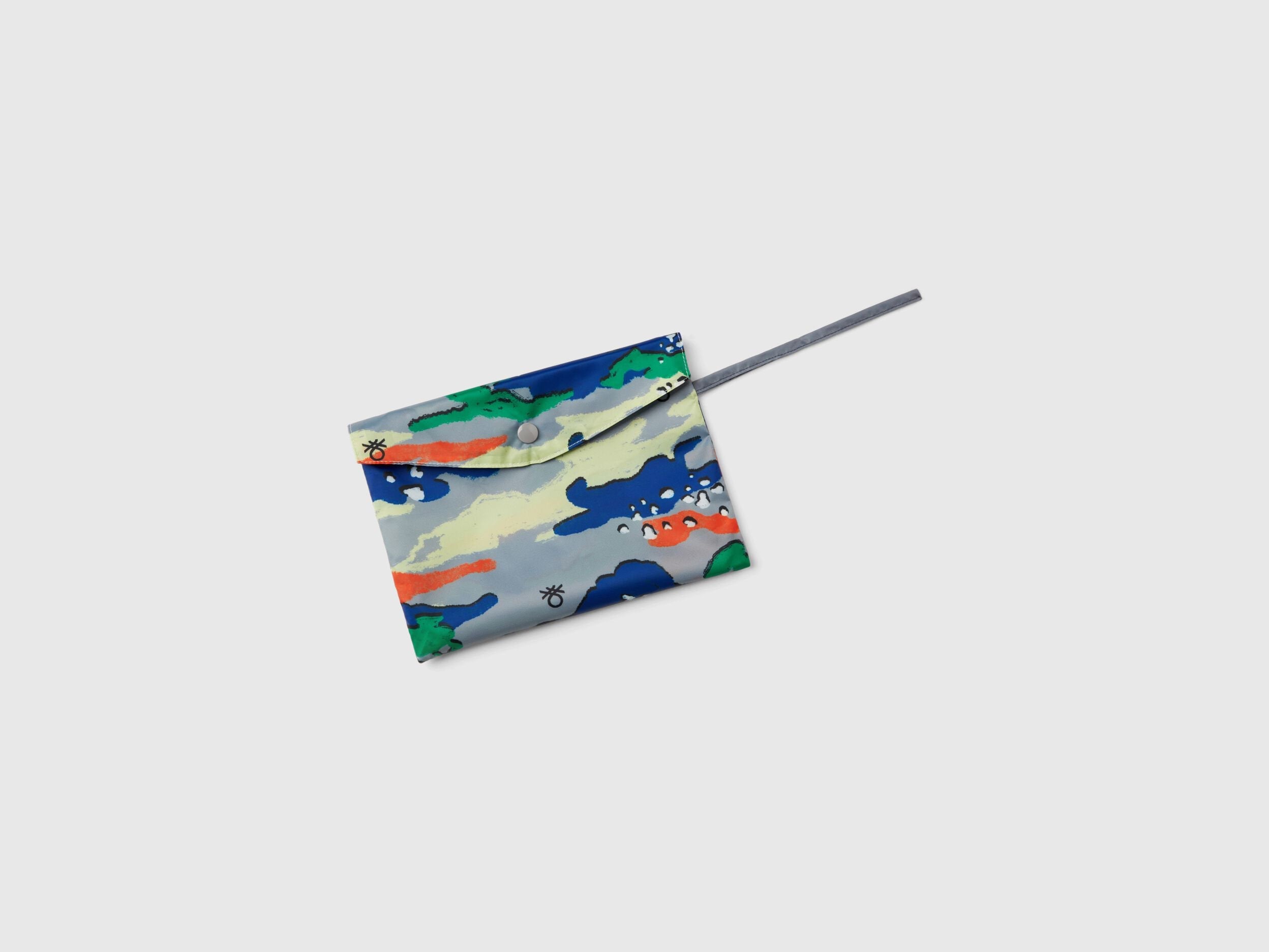 Overhead view of a colorful patterned rain poncho for kids, neatly folded into a compact square with a drawstring.