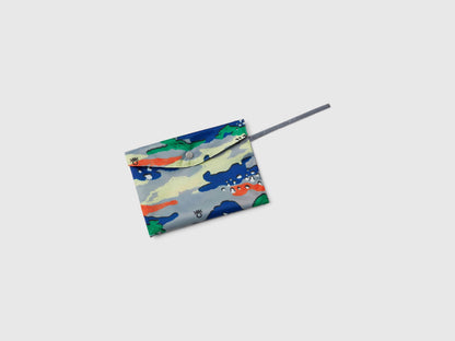 Overhead view of a colorful patterned rain poncho for kids, neatly folded into a compact square with a drawstring.