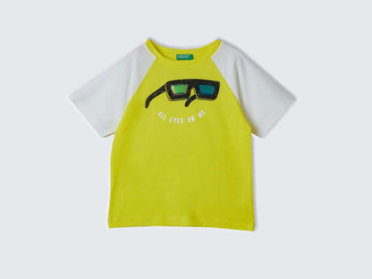 Front view of a yellow and white t-shirt for kids in Kuwait, with &quot;All Eyes On Me&quot; graphic.