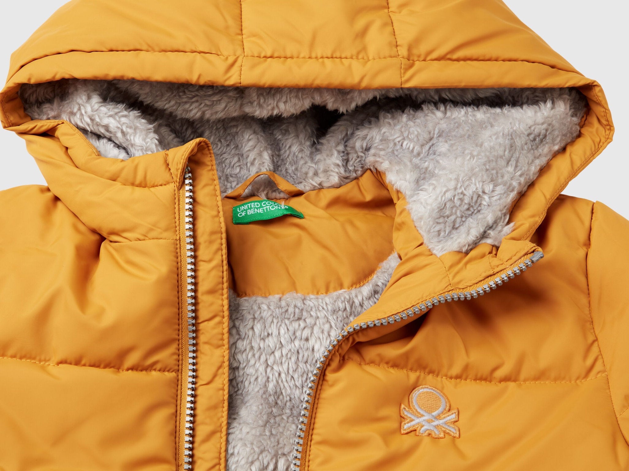 Close-up of the hood and fuzzy teddy lining of a mustard yellow Teddy Jacket, highlighting its soft texture and warmth, a great outerwear option for Kuwait.