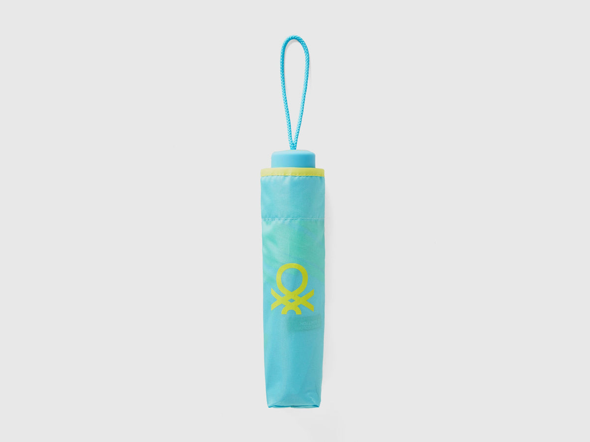 Folded light blue Benetton umbrella, compact and portable.