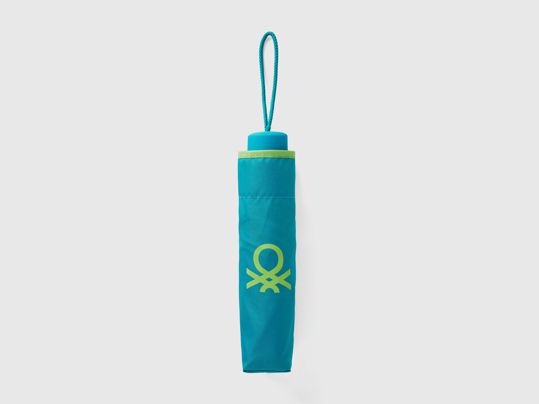 Folded light green Benetton umbrella, compact and portable.