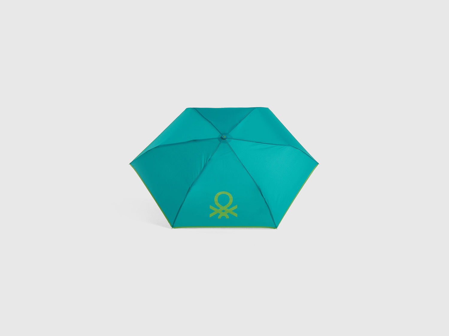 Open light green Benetton umbrella, top view for rain protection.