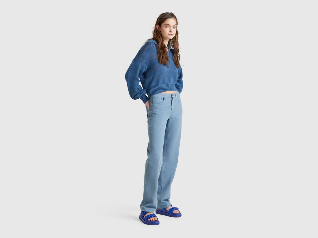 A female model wearing light blue women straight leg jeans in blue colour, paired with a white t-shirt and blazer, a stylish look in Kuwait.