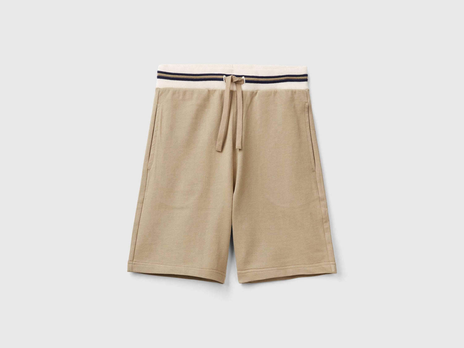 Front view of lightweight beige sweat shorts with a striped waistband.