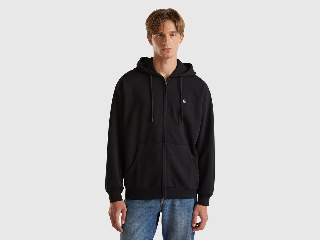 Front view of a man wearing a black hoodie with drawstring hood.