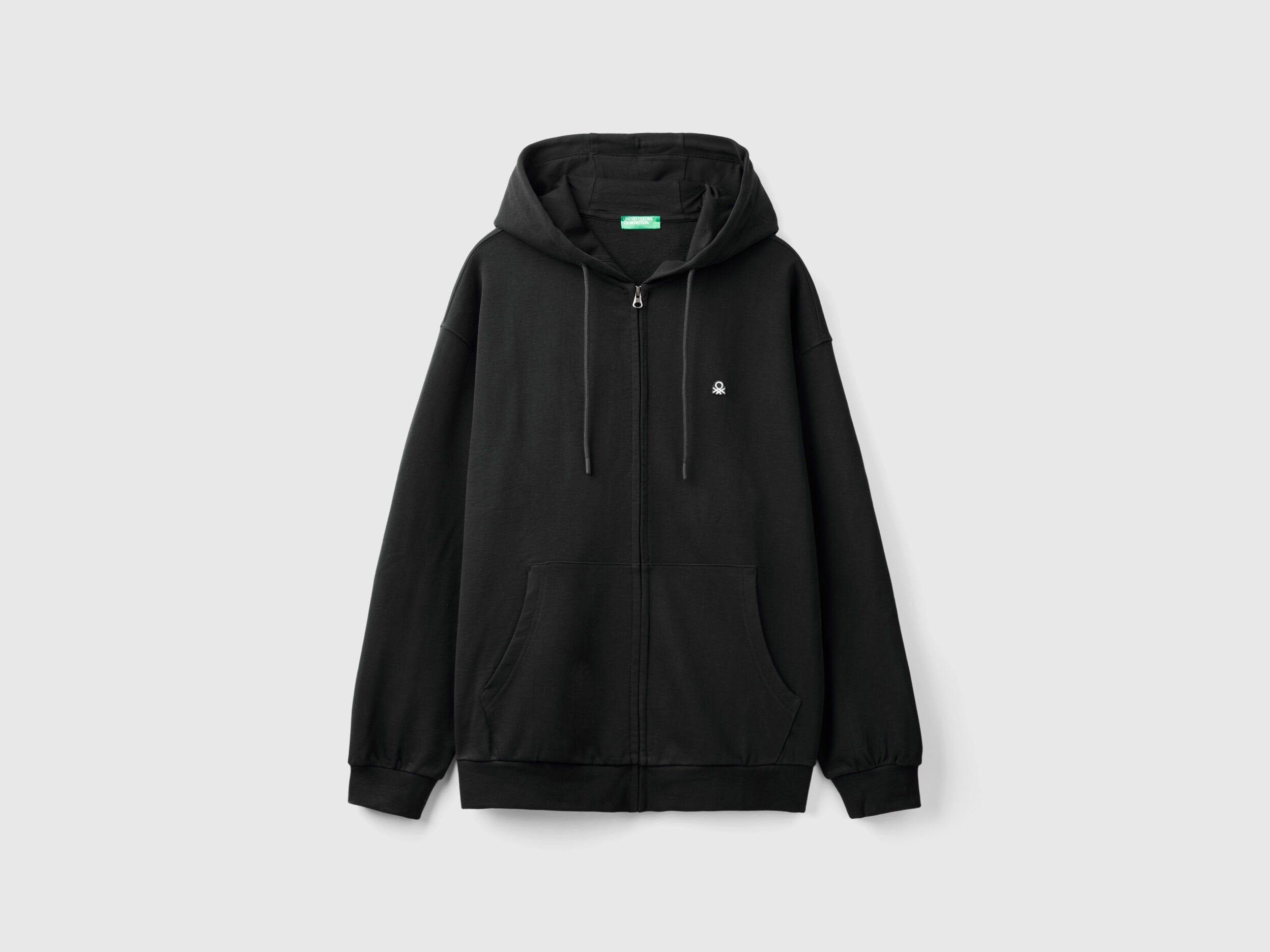 Side view of a man wearing a plain black pullover hoodie.
