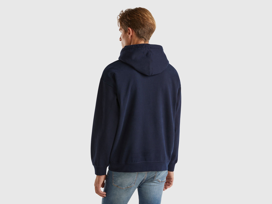 Back view of a man wearing a royal blue 100% cotton hoodie.