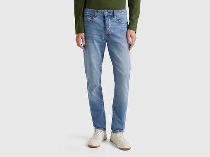 Back view of a man wearing blue five-pocket jeans.