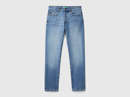 Flat lay back view of blue five-pocket jeans for men.