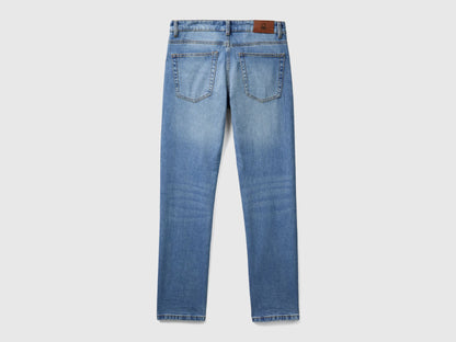 Close-up of the back pocket and leather patch on blue five-pocket jeans.