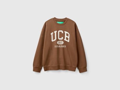 Side view of a man wearing a brown crew neck sweatshirt.