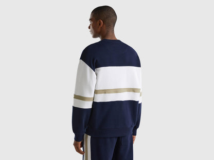 Back view of a man wearing a dark blue sweatshirt with a logo stripe.