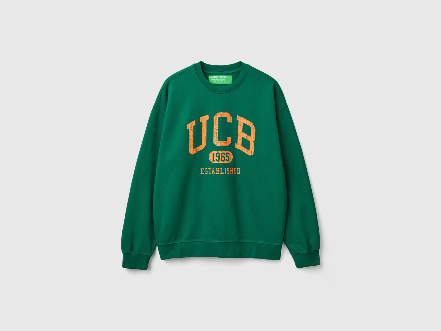 Side view of a man wearing a plain green crew neck sweatshirt.
