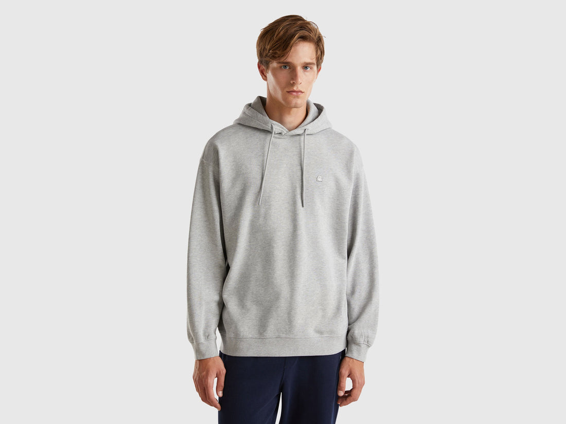 Front view of a man wearing a navy blue 100% cotton hoodie.