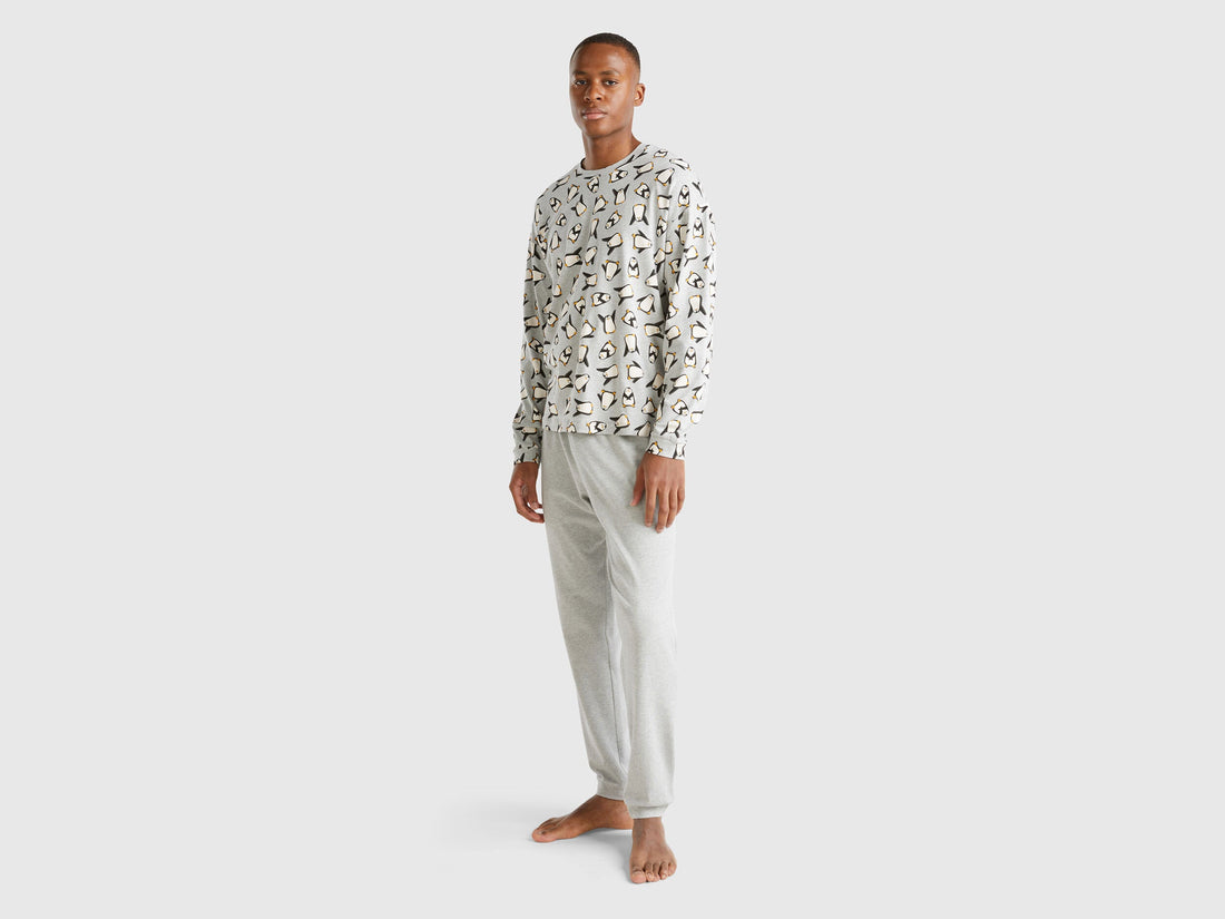 Full-length front view of a man wearing white pyjamas with a penguin print in Kuwait.