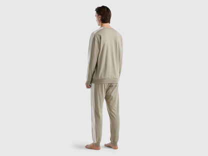 Back view of a man wearing beige pyjamas with side stripes in Kuwait.