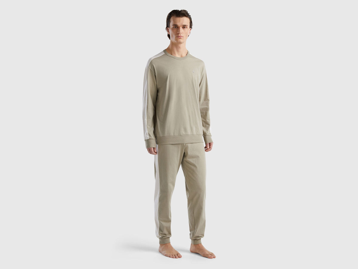 Front view of a man wearing beige pyjamas with side stripes in Kuwait.