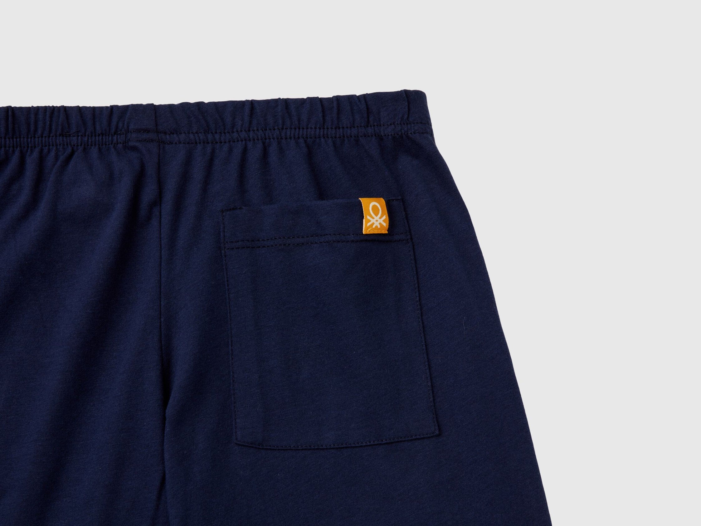 Close-up of the navy blue pyjama bottoms, highlighting the fabric texture and a small Benetton logo on the back pocket, essential details for quality pyjamas Kuwait and sleepwear Kuwait.
