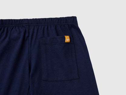 Close-up of the navy blue pyjama bottoms, highlighting the fabric texture and a small Benetton logo on the back pocket, essential details for quality pyjamas Kuwait and sleepwear Kuwait.