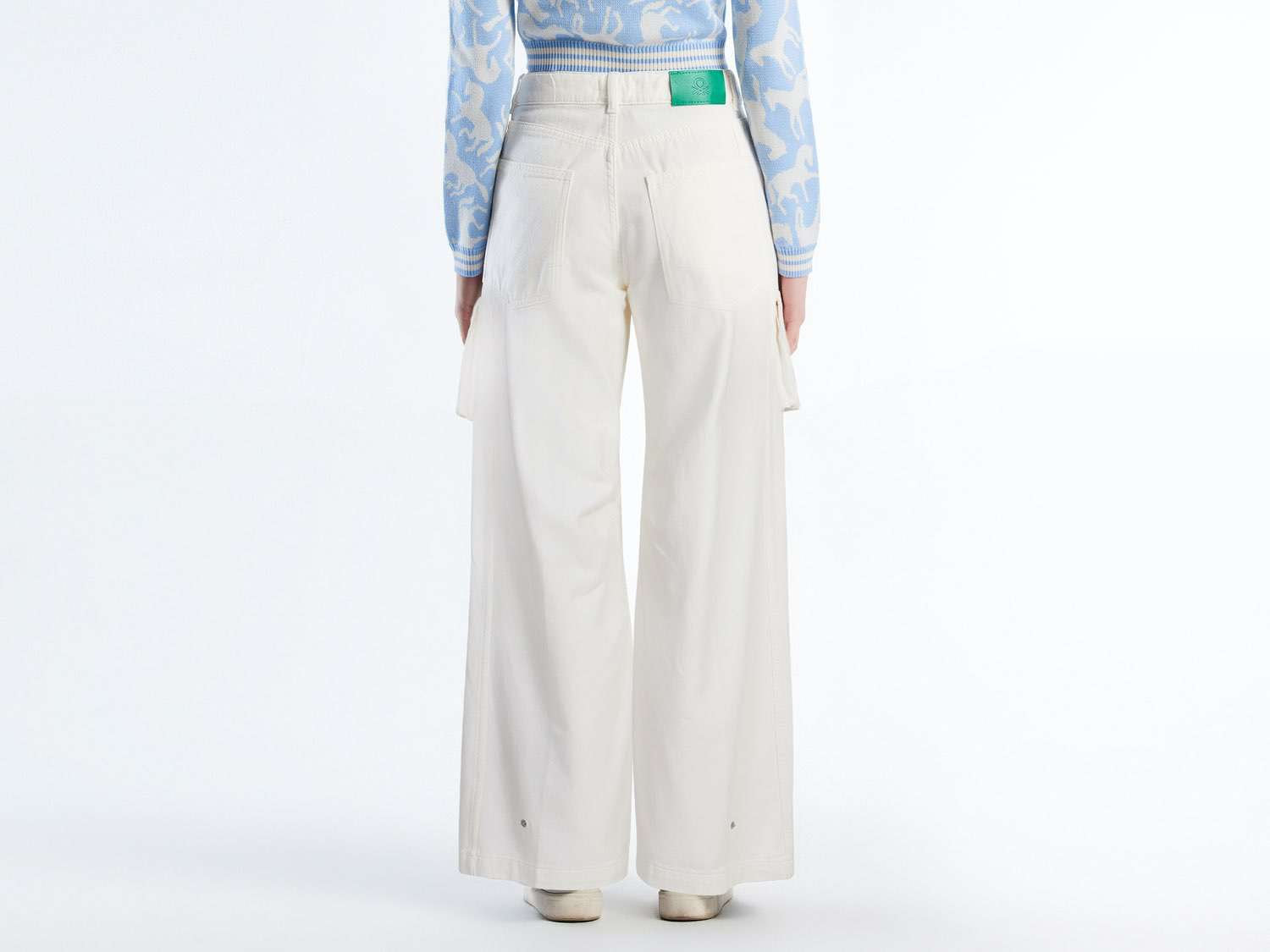 A full-length shot of the bottom half of a person wearing off-white wide-leg cargo pants Kuwait, viewed from the back.