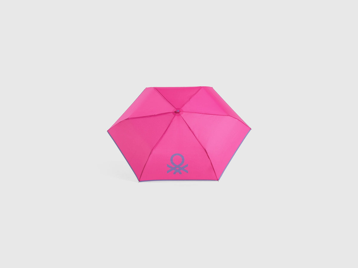 Open pink Benetton umbrella, top view for rain protection.