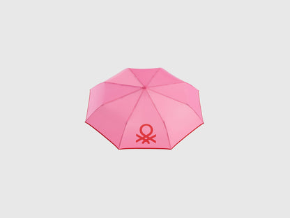 Open pink Benetton umbrella, top view for rain protection.