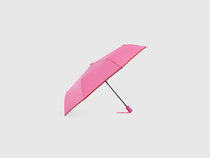 Pink Benetton umbrella, partially open, stylish rain gear.