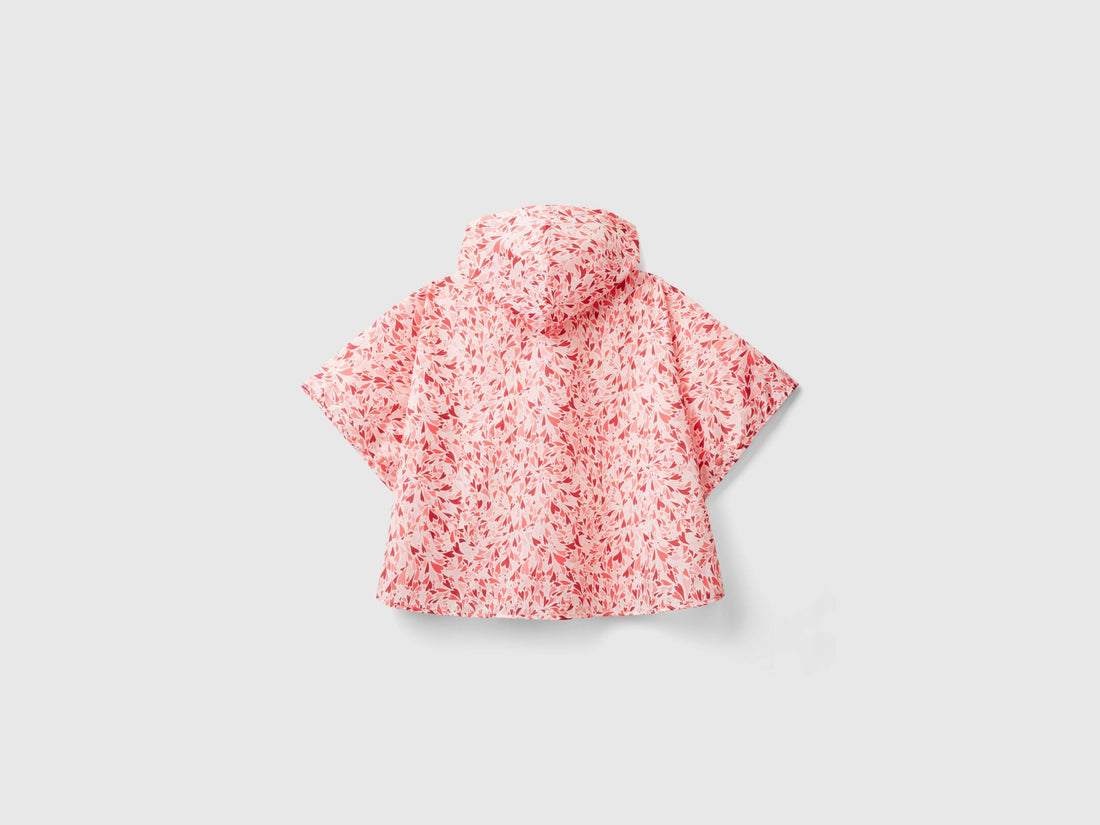 Back view of a pink and white patterned rain poncho with a hood. Loose fit.