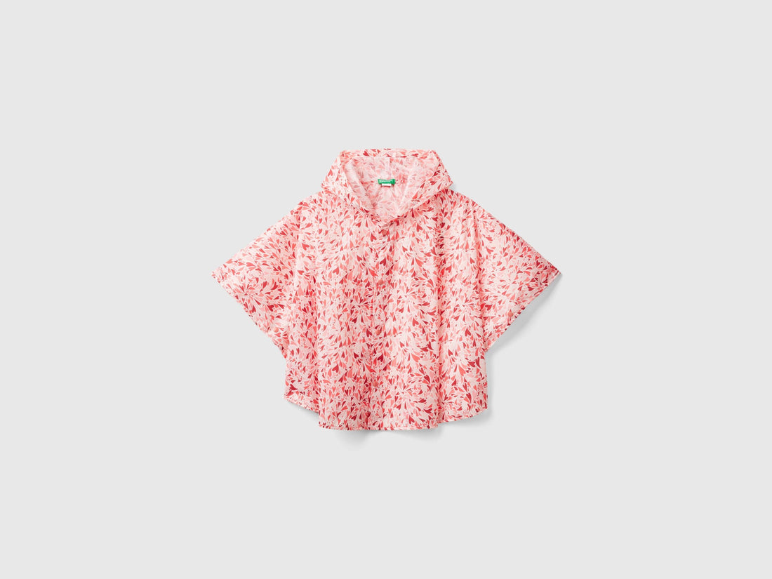 Front view of a pink and white patterned rain poncho with a hood. Lightweight outerwear.