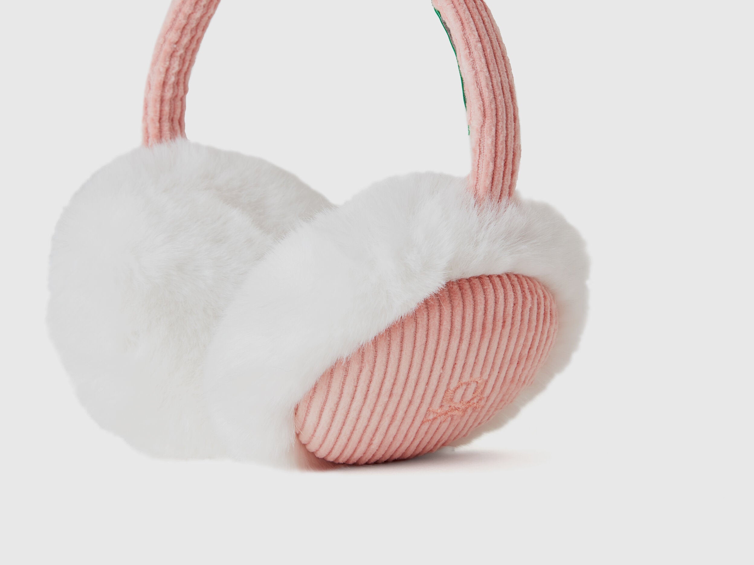 Close-up of pink and white faux fur earmuffs, ribbed detail.