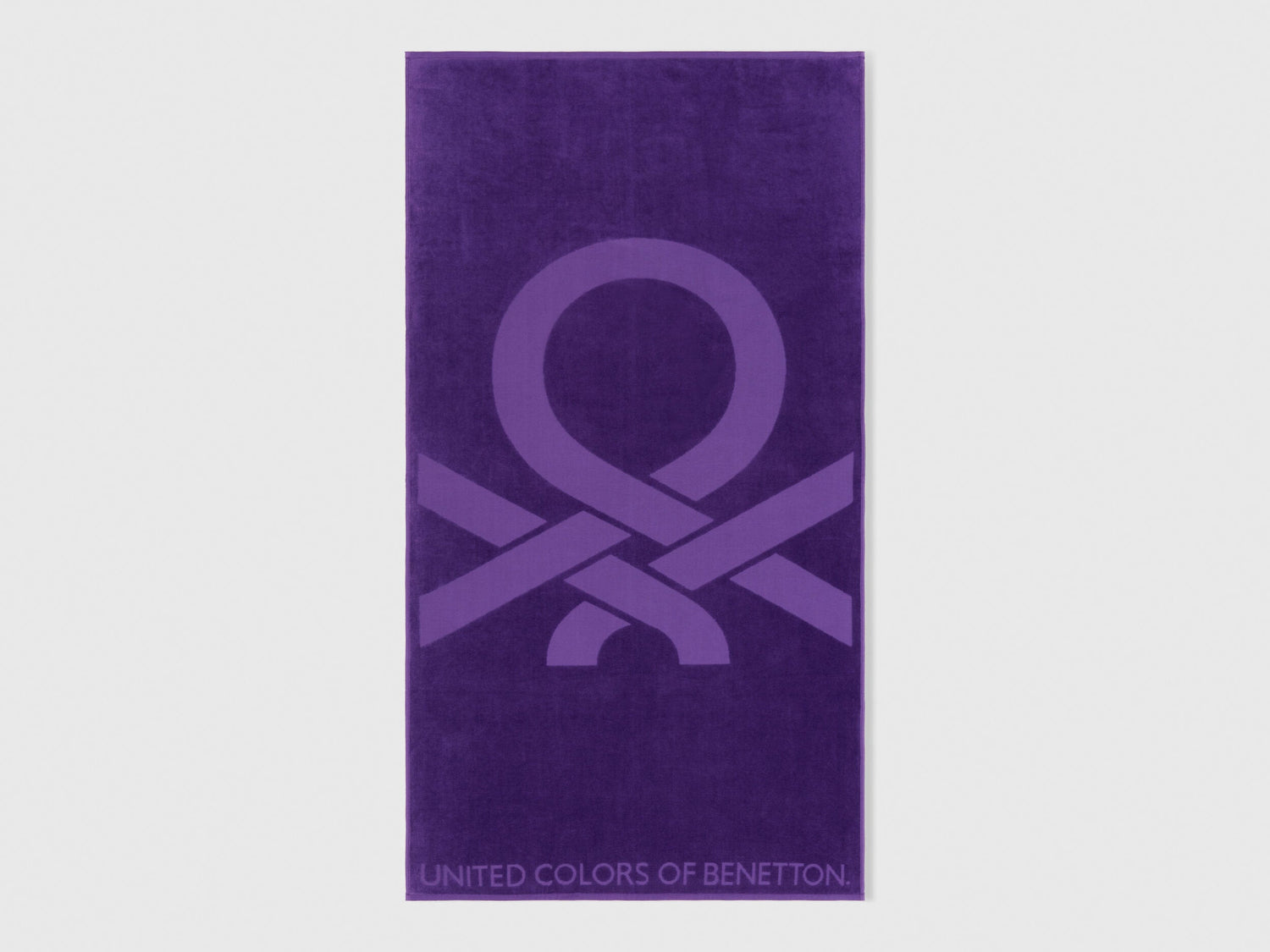 A folded purple beach towel, showing its vibrant color and plush texture.