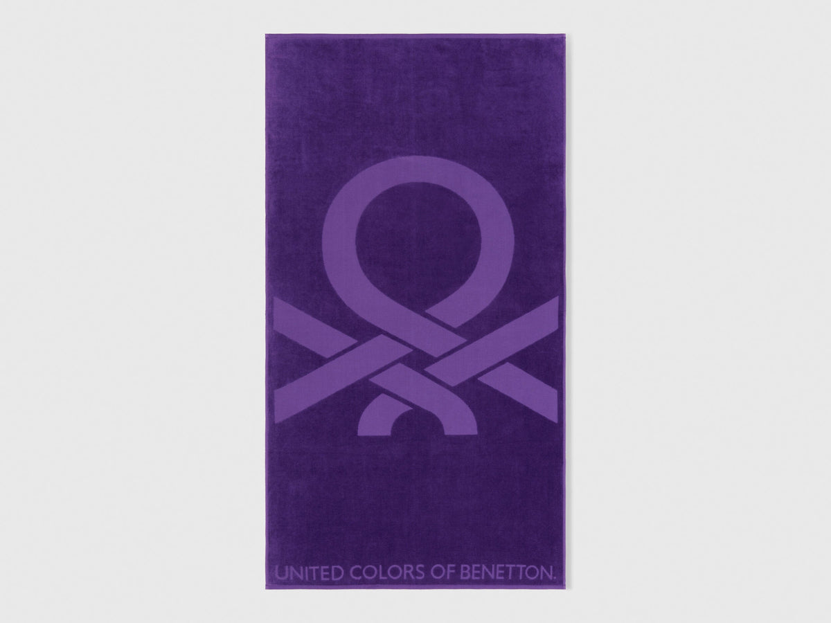 A folded purple beach towel, showing its vibrant color and plush texture.