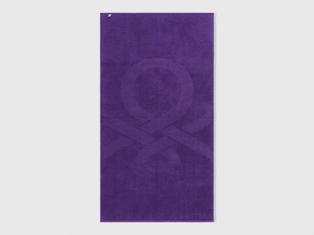 A single purple beach towel on a plain background, highlighting its full size and design.