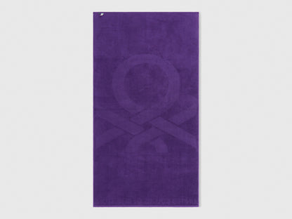 A single purple beach towel on a plain background, highlighting its full size and design.